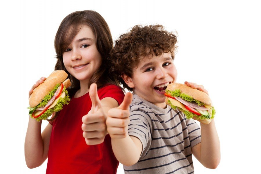 Kids eating big sandwich showing OK sign