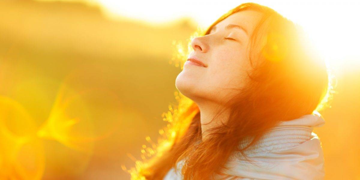 mujer con la cara iluminada por el sol